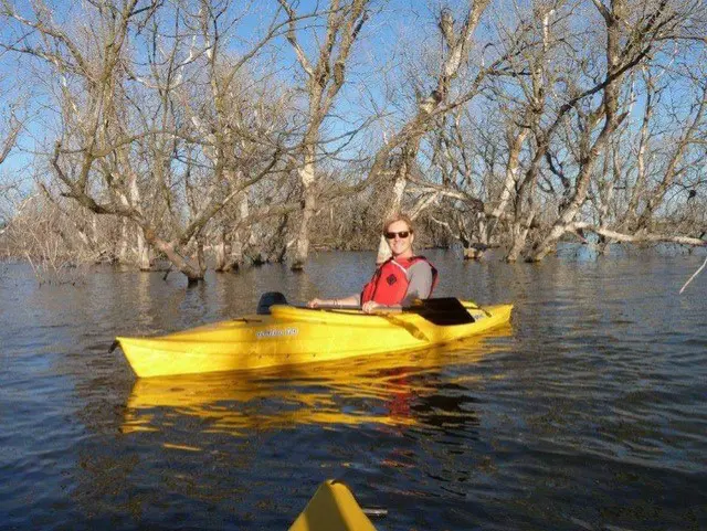 A person in a yellow kayak on water.