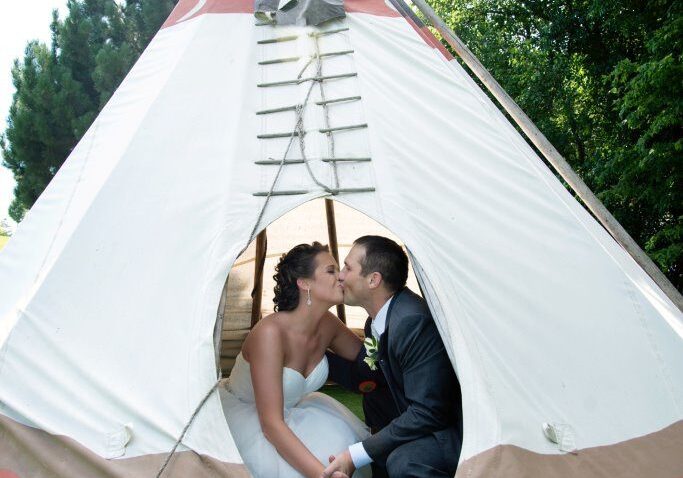 A couple kissing in the middle of an indian tent.